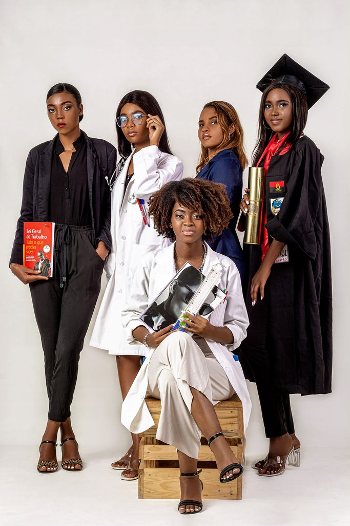 A group of African American women posing in career-specific attire on a white background.