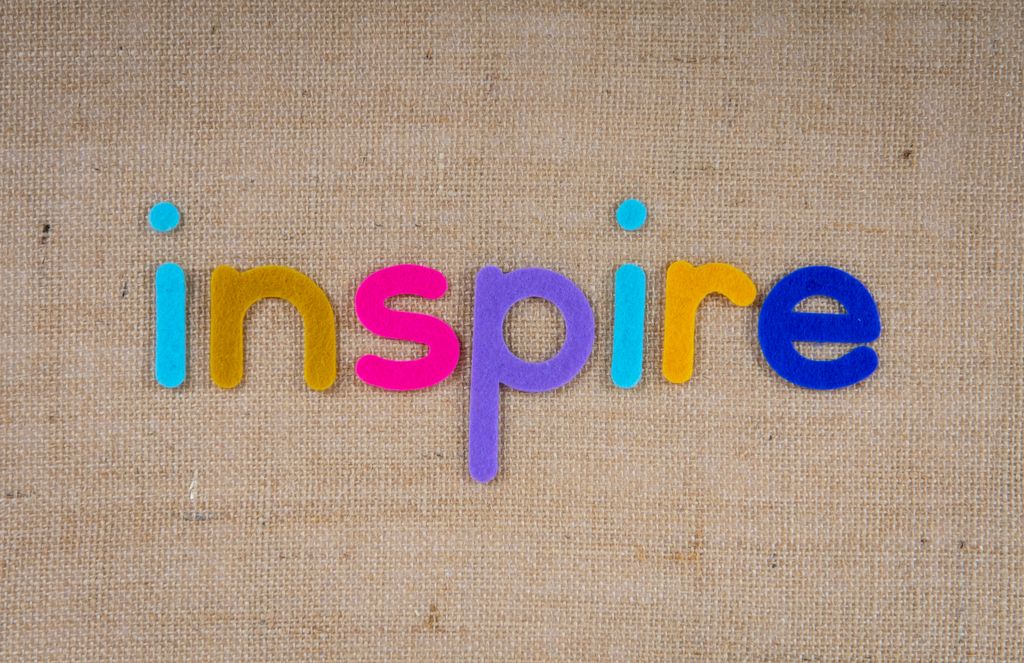 Vibrant letters forming the word "inspire" on a textured burlap background, ideal for inspiration themes.